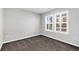 An empty bedroom with a large window, plush carpeting, and neutral paint at 806 Flora View Dr, Erie, CO 80516