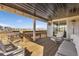 Covered deck with seating, wood railing, and mountain views at 806 Flora View Dr, Erie, CO 80516