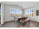 Dining room with large windows, wood floors, and a modern chandelier at 806 Flora View Dr, Erie, CO 80516