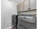 Well-equipped laundry room with modern washer and dryer, and storage cabinets at 806 Flora View Dr, Erie, CO 80516
