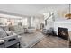Bright living room with a fireplace, soft carpet and hardwood flooring leading to the upper level at 806 Flora View Dr, Erie, CO 80516