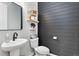 Modern powder room featuring sleek black and gray accents, floating shelves, and stylish fixtures at 806 Flora View Dr, Erie, CO 80516