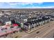 Expansive aerial view of modern townhouses, city skyline, and nearby gas station in an urban setting at 5188 Ward Rd, Wheat Ridge, CO 80033