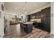 Modern kitchen with dark cabinets, hardwood floors, and a center island with seating at 5188 Ward Rd, Wheat Ridge, CO 80033