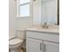 Well-lit bathroom with white vanity, toilet, tub, and a window that provides natural light at 11493 E Briarwood Cir, Centennial, CO 80112