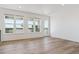 Open-concept living room with hardwood floors, recessed lighting, and multiple windows with scenic views at 11493 E Briarwood Cir, Centennial, CO 80112