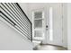 Modern staircase with black metal railings and light wood flooring leading to a bright entryway at 11493 E Briarwood Cir, Centennial, CO 80112
