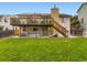 Spacious backyard with green grass, patio seating and a second-story deck at 2104 Vineyard Dr, Castle Rock, CO 80104