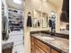 Elegant bathroom with marble countertop, double mirrors and doorway into walk-in closet at 2104 Vineyard Dr, Castle Rock, CO 80104
