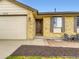 Close-up of a brick home with a wooden front door, matching shutters, and a quaint outdoor seating space at 2104 Vineyard Dr, Castle Rock, CO 80104