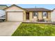 Charming brick home featuring a well-maintained lawn and a cozy seating area near the front entrance at 2104 Vineyard Dr, Castle Rock, CO 80104