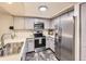 Modern kitchen with stainless steel appliances, grey cabinets, and updated countertops and flooring at 2104 Vineyard Dr, Castle Rock, CO 80104