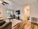 Inviting living room featuring hardwood floors, modern TV, stylish decor, and sliding glass door leading to outdoor deck at 2104 Vineyard Dr, Castle Rock, CO 80104