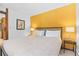 Bedroom with queen bed, mustard yellow accent wall, and nightstands at 1140 Ski Hill Rd # 25, Breckenridge, CO 80424
