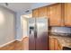 Bright kitchen featuring stainless steel refrigerator, granite countertops, and wooden cabinets at 7453 E 26Th Ave # 2, Denver, CO 80238
