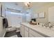 Bright bathroom features a double sink vanity, white cabinets, and tiled shower-tub combination at 6877 Bryant Ct, Denver, CO 80221