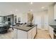 Open kitchen view with a large island, stainless steel sink, modern countertops, and adjacent dining area at 6877 Bryant Ct, Denver, CO 80221