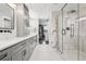 Contemporary bathroom with double vanity, sleek cabinetry, glass-enclosed shower, and walk-in closet at 7152 E Hinsdale Pl, Centennial, CO 80112