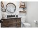 Farmhouse style half bathroom featuring shiplap walls, custom vanity and a round mirror at 7152 E Hinsdale Pl, Centennial, CO 80112