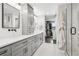 Bright bathroom with a double vanity, sleek shower, and a glimpse into the walk-in closet at 7152 E Hinsdale Pl, Centennial, CO 80112
