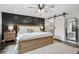 Cozy bedroom featuring a ceiling fan, accent wall and sliding barn door to the ensuite bathroom at 7152 E Hinsdale Pl, Centennial, CO 80112