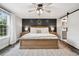 Comfortable bedroom with dark wood accent wall, ceiling fan, and access to the ensuite bathroom at 7152 E Hinsdale Pl, Centennial, CO 80112