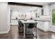 Bright kitchen with white cabinets, a large island with seating, and hardwood flooring at 7152 E Hinsdale Pl, Centennial, CO 80112