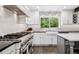 Bright and airy kitchen with stainless steel appliances, subway tile backsplash, and black countertops at 7152 E Hinsdale Pl, Centennial, CO 80112