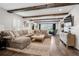 Inviting living room boasts exposed beams, a cozy sectional sofa, and a neutral color palette, perfect for relaxation at 7152 E Hinsdale Pl, Centennial, CO 80112