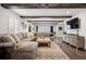 Comfortable living room featuring exposed beams, sectional sofa, and view into other rooms with natural light at 7152 E Hinsdale Pl, Centennial, CO 80112