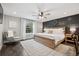 Serene main bedroom offers a neutral color palette, decorative accent wall, and ample natural light from the windows at 7152 E Hinsdale Pl, Centennial, CO 80112