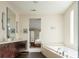 Bright bathroom with a soaking tub, dual vanity, and a pass-through view to the primary bedroom at 907 E 22Nd Ave, Denver, CO 80205