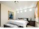 Well-lit bedroom features a gray upholstered bench, decorative lamps, and modern decor at 907 E 22Nd Ave, Denver, CO 80205