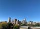 Vibrant city skyline view, showcasing modern architecture and lush greenery against a clear blue sky at 907 E 22Nd Ave, Denver, CO 80205