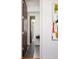 Hallway with modern art and gray scale tiling leads to floating sink bathroom at 907 E 22Nd Ave, Denver, CO 80205