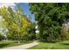 A park pathway lined with mature trees offering a serene and shady retreat in a verdant setting at 907 E 22Nd Ave, Denver, CO 80205