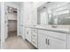 Bathroom featuring double sinks, white cabinetry, and large mirror at 16478 W 92Nd Pl, Arvada, CO 80007