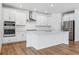 Modern kitchen featuring an island, white cabinets, stainless steel appliances, and subway tile backsplash at 16478 W 92Nd Pl, Arvada, CO 80007