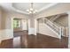 Elegant foyer showcasing dark wood floors, decorative pillars, and a staircase with white railings at 1339 Sidewinder Cir, Castle Rock, CO 80108