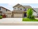 Charming two-story home featuring a three-car garage, stone accents, and manicured lawn at 1339 Sidewinder Cir, Castle Rock, CO 80108