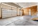 Spacious two car garage featuring high ceilings, with a concrete floor and wooden staircase at 1339 Sidewinder Cir, Castle Rock, CO 80108