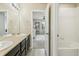 Bathroom with double vanity leading to a bedroom featuring a ceiling fan and crib at 24356 E Powers Ave, Aurora, CO 80016