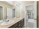 Bathroom with double vanity leading to a bedroom with a ceiling fan at 24356 E Powers Ave, Aurora, CO 80016