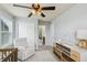 Bedroom featuring a rocking chair, dresser with changing table, and view of adjoining bathroom at 24356 E Powers Ave, Aurora, CO 80016