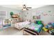 Brightly decorated bedroom featuring two twin beds, ceiling fan and colorful wall decor at 24356 E Powers Ave, Aurora, CO 80016