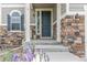 Charming front entry with stone accents, a blue door, and manicured landscaping at 24356 E Powers Ave, Aurora, CO 80016