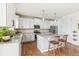 Well-lit kitchen featuring white cabinets, stainless steel appliances, granite countertops, and island seating at 24356 E Powers Ave, Aurora, CO 80016