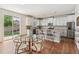 Bright kitchen with white cabinets, stainless steel appliances, and a glass table with seating at 24356 E Powers Ave, Aurora, CO 80016