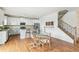 Bright kitchen with granite countertops, island with stools, stainless steel appliances, and staircase access at 24356 E Powers Ave, Aurora, CO 80016
