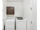 Laundry room with dark wood cabinets and modern, front-loading washer and dryer at 24356 E Powers Ave, Aurora, CO 80016